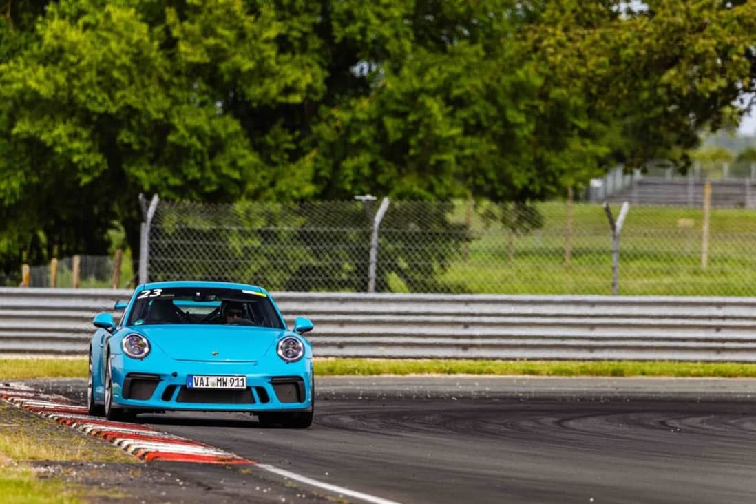 Porsche bleue en plein virage sur le Circuit du Val de Vienne